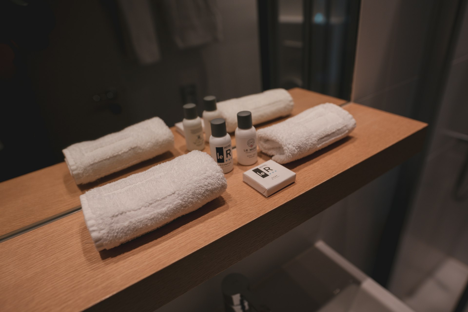 a bathroom counter with towels and bottles on it